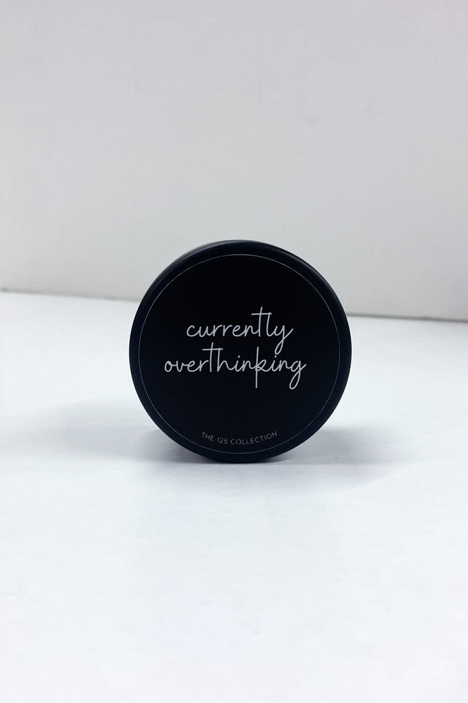 4oz candle in a black tin with the lid that reads currently overthinking